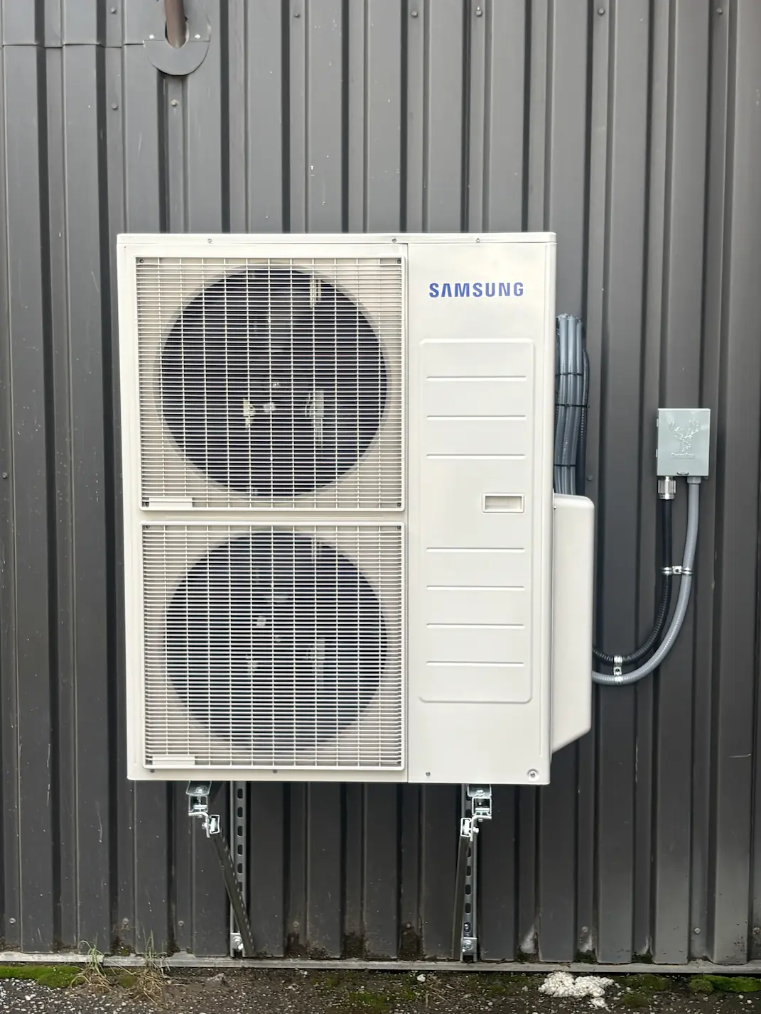 Basement utility area with a water heater, metal ductwork, flexible insulated ducts, and a green Air King 400 humidifier attached to the duct.