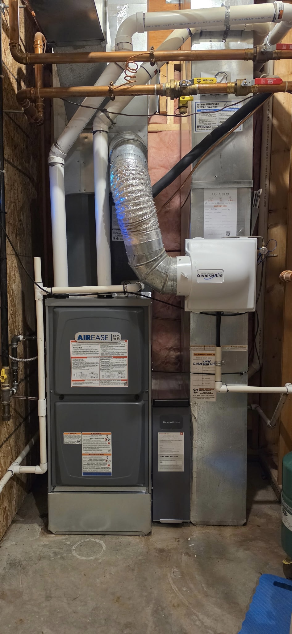 Basement utility area featuring a gray cylindrical water heater next to an Airease HVAC furnace with connected ductwork and a GeneralAire humidifier.