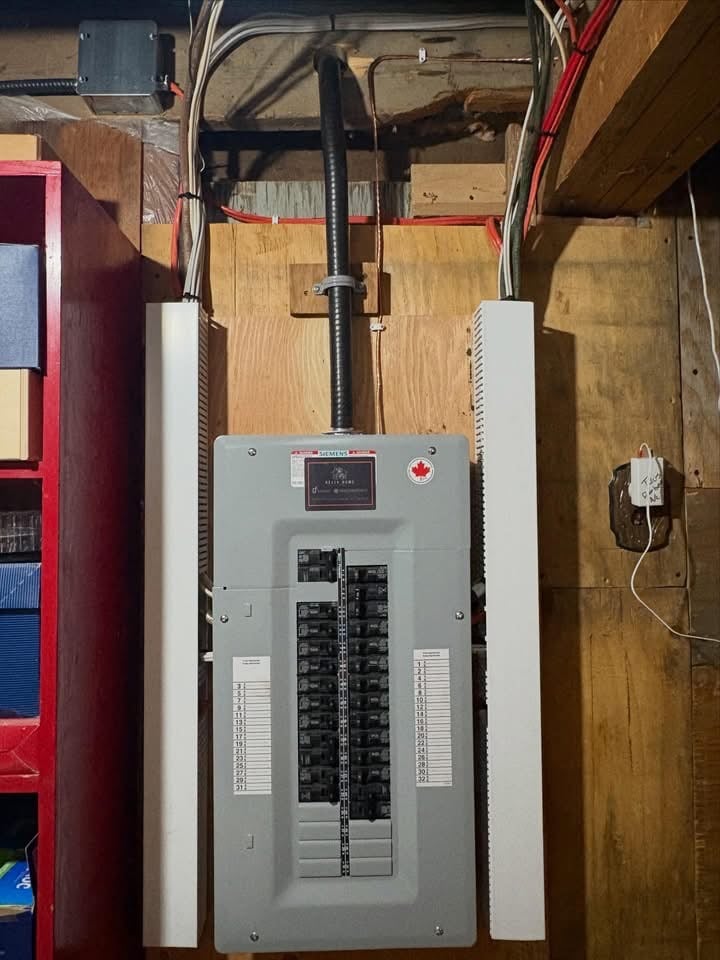 Gray Siemens electrical circuit breaker panel with multiple switches mounted on a wooden wall, surrounded by wires and adjacent shelving.